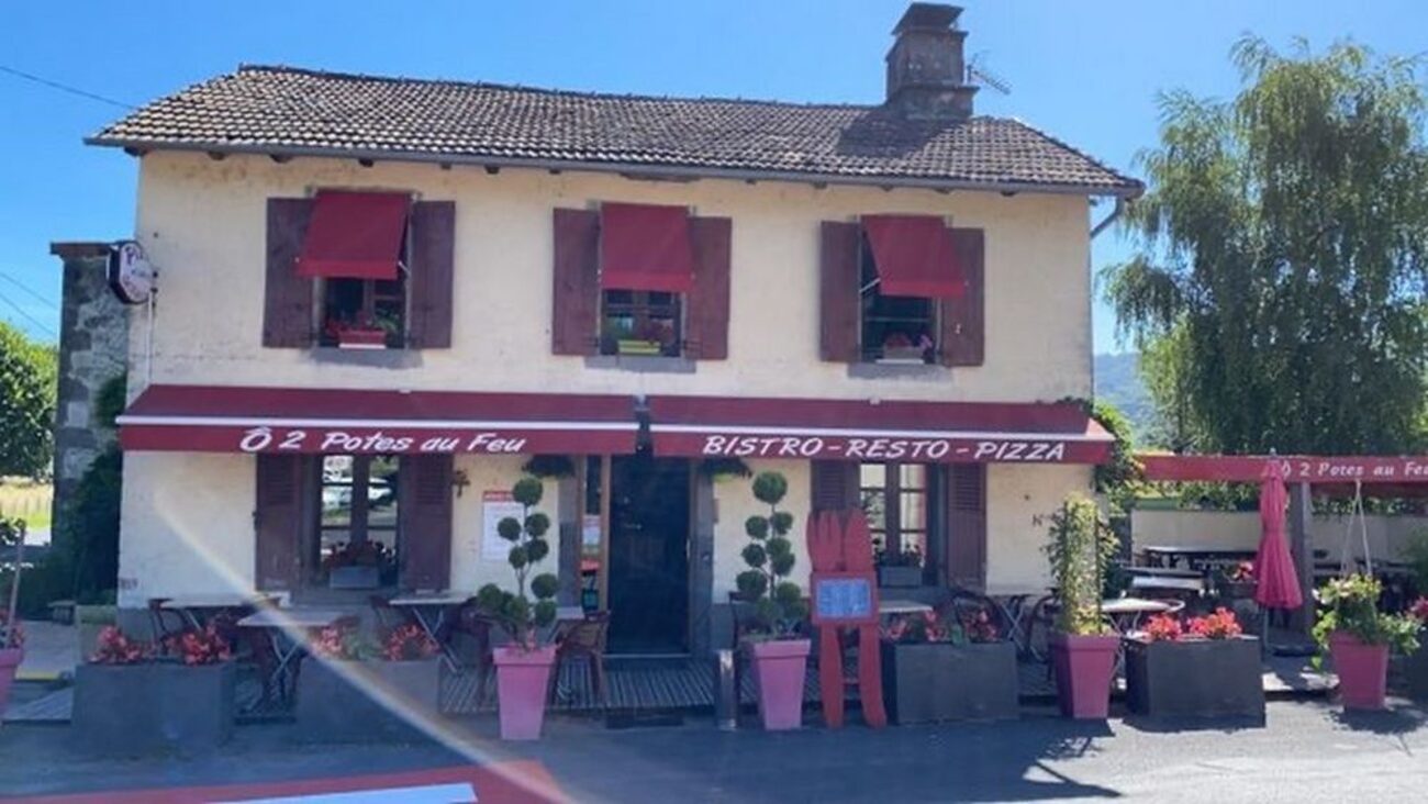 La façade d'Ô 2 Potes au Feu à Polminhac, volets et auvents rouges